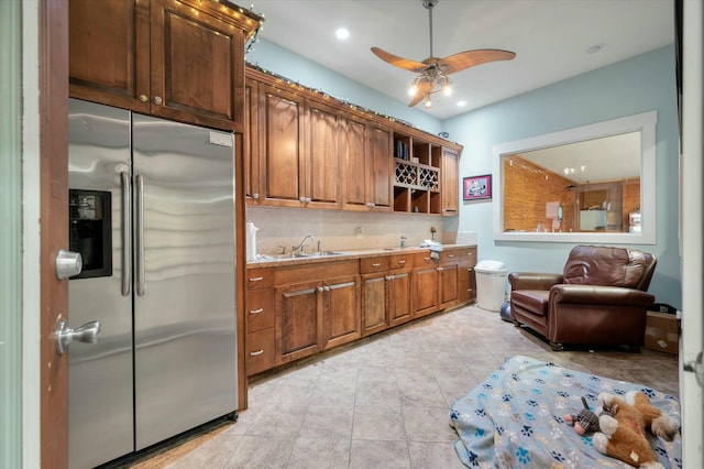 kitchen with stainless steel refrigerator with ice dispenser, tasteful backsplash, ceiling fan, sink, and light tile patterned floors