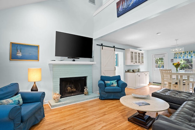 living room featuring light hardwood / wood-style floors, a barn door, and a fireplace