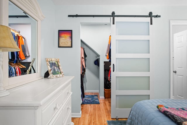 bedroom featuring light hardwood / wood-style flooring and a barn door