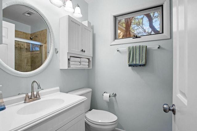 bathroom featuring vanity, toilet, and walk in shower