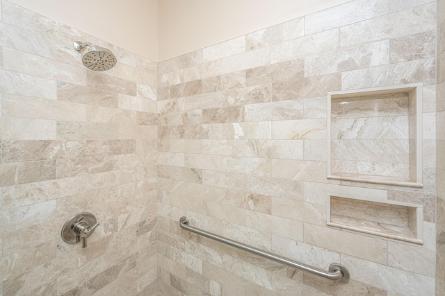 interior details featuring a tile shower