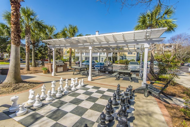 surrounding community with area for grilling, a patio area, and a pergola