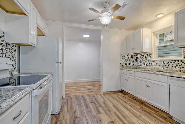 kitchen featuring light wood-style flooring, white appliances, a sink, white cabinetry, and decorative backsplash