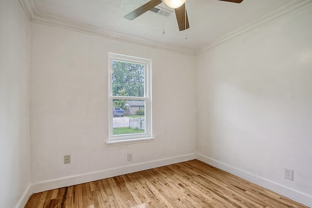 unfurnished room with baseboards, light wood finished floors, visible vents, and crown molding