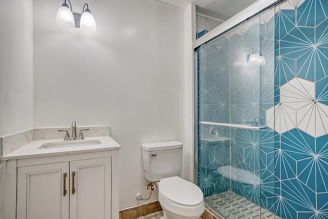 bathroom featuring vanity, a shower stall, and toilet