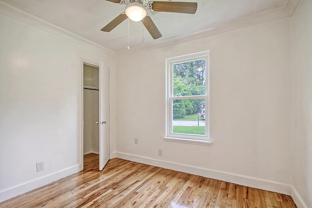 unfurnished bedroom featuring light wood-style floors, crown molding, and baseboards