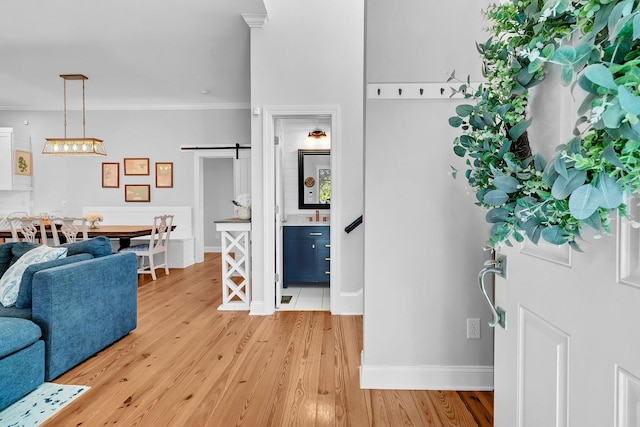 foyer with hardwood / wood-style flooring, crown molding, and a barn door