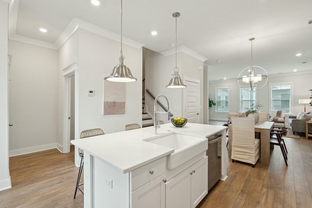 kitchen with pendant lighting, a center island with sink, open floor plan, white cabinets, and dishwasher