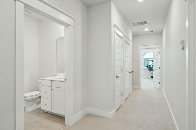 hall with light carpet, baseboards, visible vents, and recessed lighting