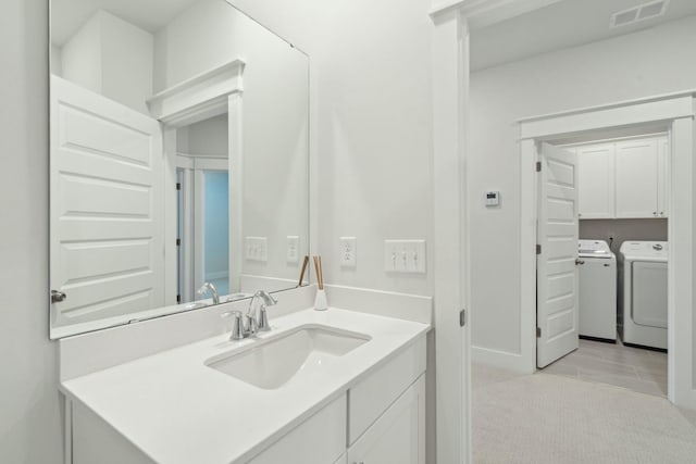 bathroom featuring independent washer and dryer, vanity, and visible vents