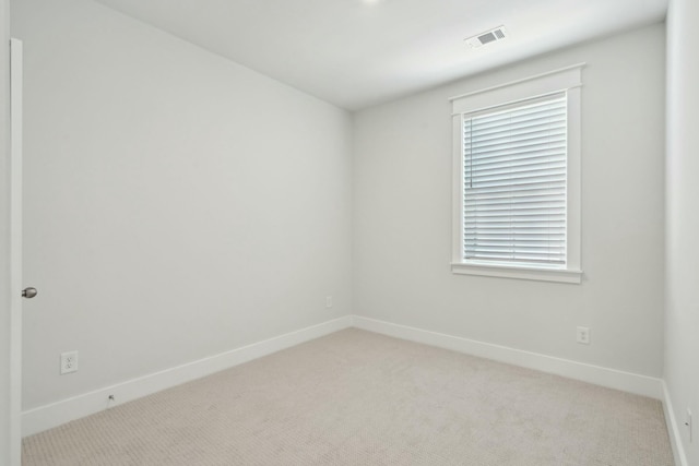 unfurnished room featuring light carpet, visible vents, and baseboards