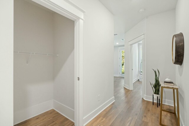 hall featuring light wood finished floors, recessed lighting, and baseboards