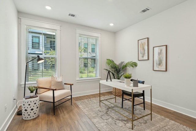 home office featuring visible vents, baseboards, and wood finished floors