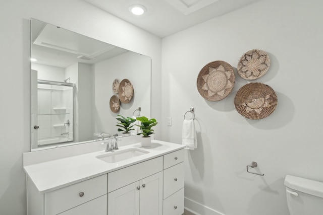 bathroom with toilet, a shower with door, baseboards, and vanity