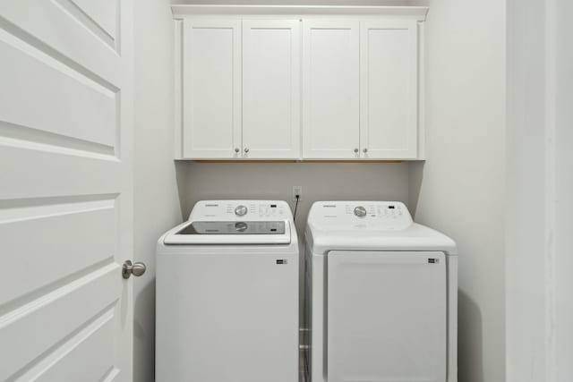 clothes washing area with cabinet space and separate washer and dryer