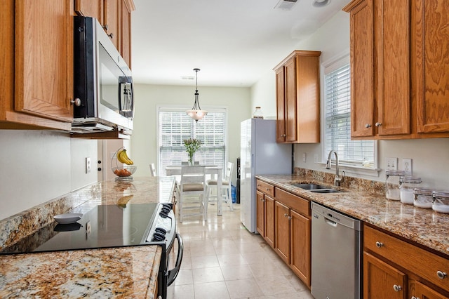 kitchen with plenty of natural light, brown cabinetry, stainless steel appliances, and a sink