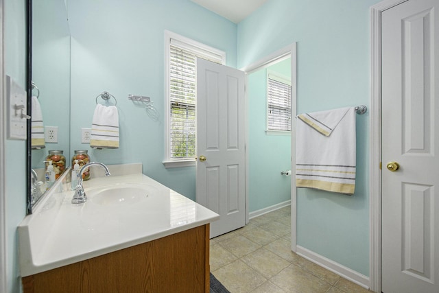 bathroom with baseboards, vanity, and tile patterned floors