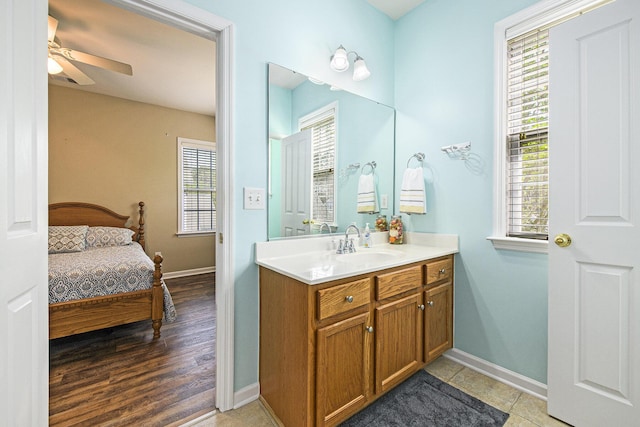 bathroom with ensuite bath, baseboards, vanity, and ceiling fan