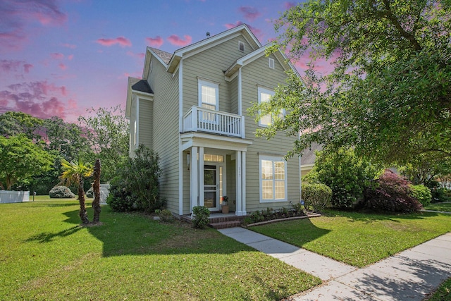 traditional-style home with a front lawn and a balcony