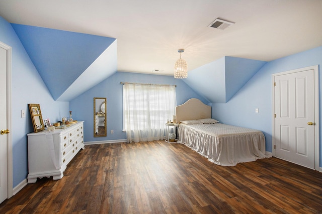 bedroom featuring lofted ceiling, baseboards, wood finished floors, and visible vents
