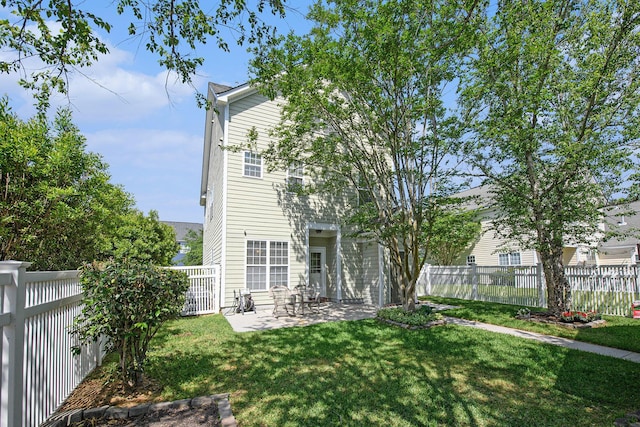 back of house featuring a lawn, a patio, and a fenced backyard