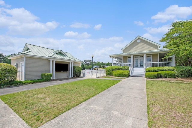 view of front of home featuring a standing seam roof, french doors, a porch, a front yard, and metal roof