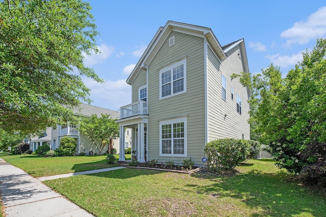 traditional-style home featuring a front lawn and a balcony