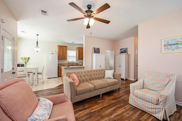 living area featuring ceiling fan, baseboards, dark wood-type flooring, and visible vents