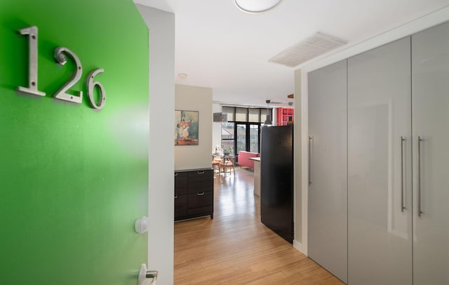 corridor featuring floor to ceiling windows and light wood-type flooring