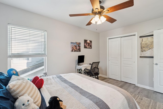 bedroom with ceiling fan, light wood finished floors, a closet, and baseboards