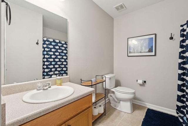 bathroom featuring toilet, vanity, baseboards, visible vents, and tile patterned floors