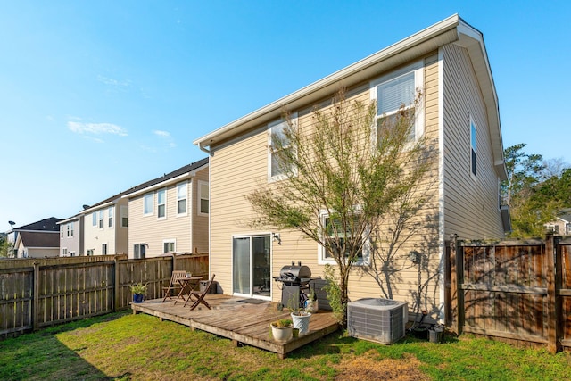 back of property featuring a deck, a yard, a fenced backyard, and cooling unit