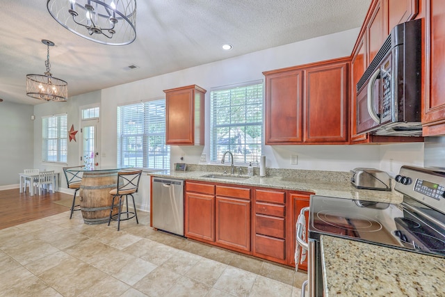 111 Kapalua Run, Summerville, SC 29483 - kitchen with appliances with stainless steel finishes, a sink, a chandelier, light stone countertops, and pendant lighting