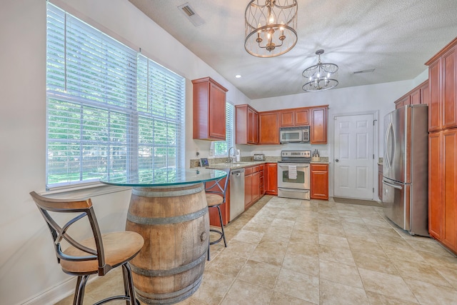 111 Kapalua Run, Summerville, SC 29483 - kitchen with appliances with stainless steel finishes, a chandelier, a sink, a kitchen breakfast bar, and a peninsula