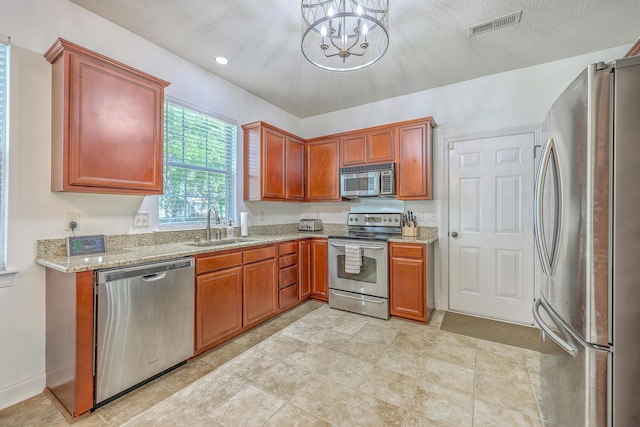 111 Kapalua Run, Summerville, SC 29483 - kitchen with appliances with stainless steel finishes, a sink, a chandelier, light stone counters, and recessed lighting