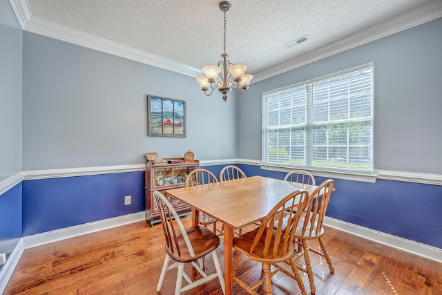 111 Kapalua Run, Summerville, SC 29483 - dining room with a textured ceiling, a chandelier, plenty of natural light, wood-type flooring, and crown molding