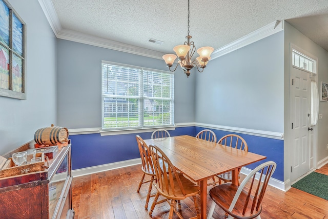 111 Kapalua Run, Summerville, SC 29483 - dining room featuring hardwood / wood-style flooring, a chandelier, a textured ceiling, ornamental molding, and baseboards