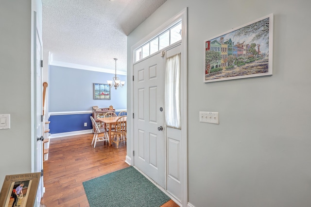 111 Kapalua Run, Summerville, SC 29483 - entryway with a chandelier, a textured ceiling, wood-type flooring, crown molding, and baseboards