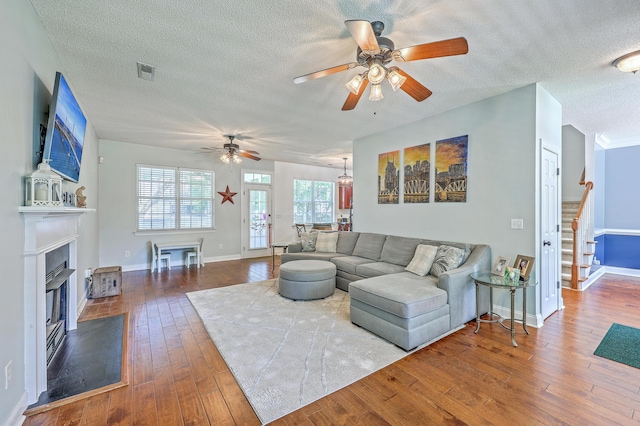 111 Kapalua Run, Summerville, SC 29483 - living room with ceiling fan, a textured ceiling, hardwood / wood-style floors, a glass covered fireplace, and stairs