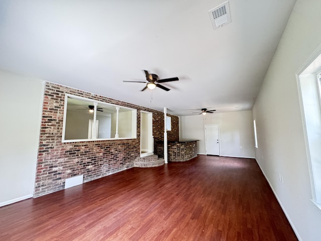 710 Gadsden Loop, Walterboro, SC 29488 - unfurnished living room featuring ceiling fan, brick wall, wood finished floors, and baseboards