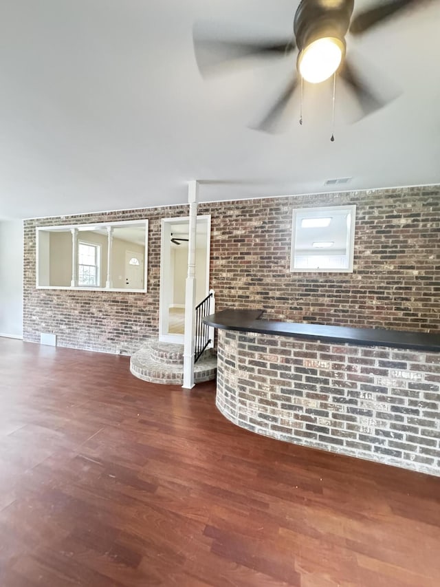 710 Gadsden Loop, Walterboro, SC 29488 - unfurnished living room featuring brick wall, a ceiling fan, and wood finished floors