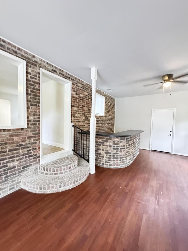 710 Gadsden Loop, Walterboro, SC 29488 - unfurnished living room featuring brick wall, wood finished floors, and a ceiling fan
