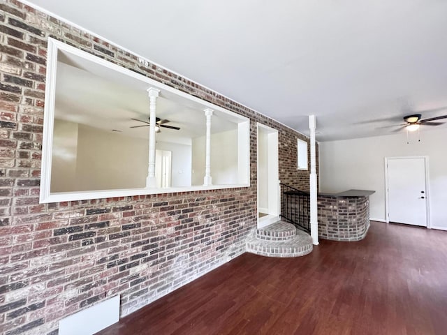 710 Gadsden Loop, Walterboro, SC 29488 - unfurnished living room featuring a ceiling fan, brick wall, and wood finished floors