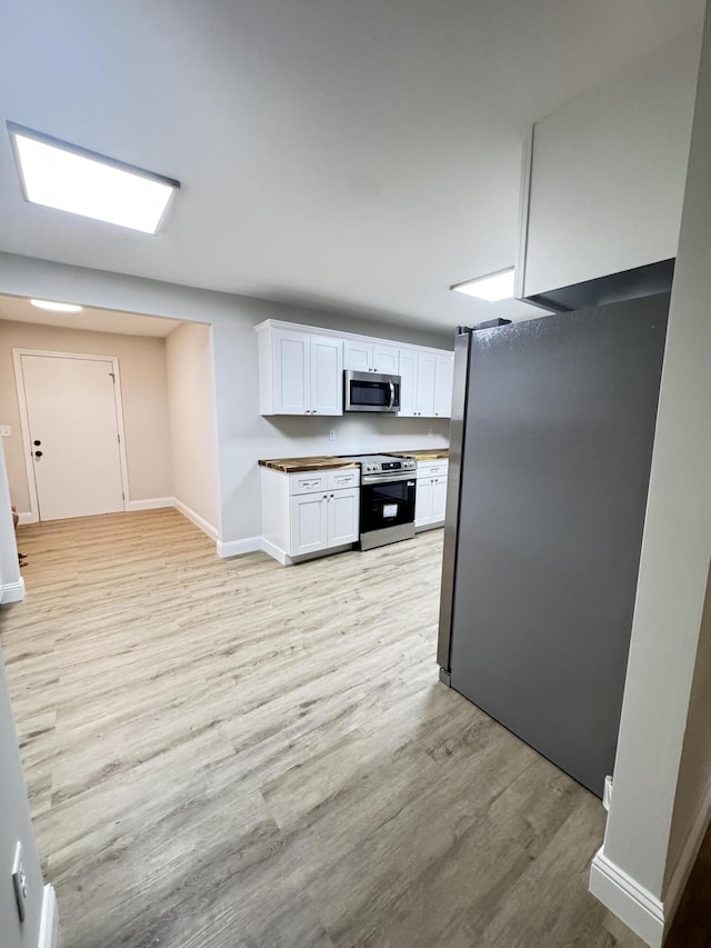 710 Gadsden Loop, Walterboro, SC 29488 - kitchen with stainless steel appliances, light wood-style floors, white cabinets, and baseboards