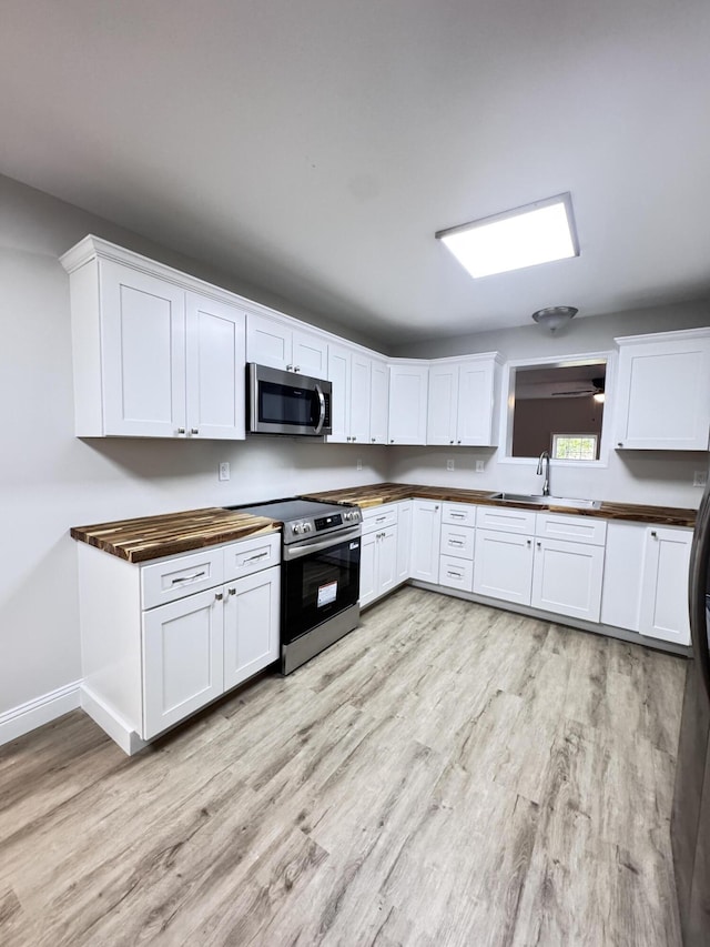 710 Gadsden Loop, Walterboro, SC 29488 - kitchen with appliances with stainless steel finishes, a sink, light wood finished floors, and white cabinets