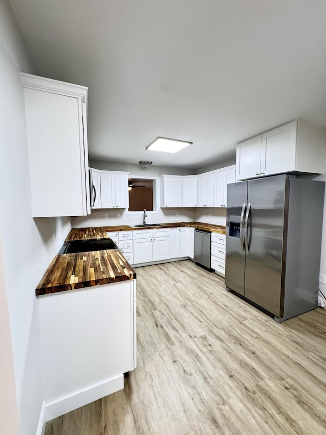 710 Gadsden Loop, Walterboro, SC 29488 - kitchen with stainless steel appliances, wood counters, light wood-type flooring, white cabinets, and a sink