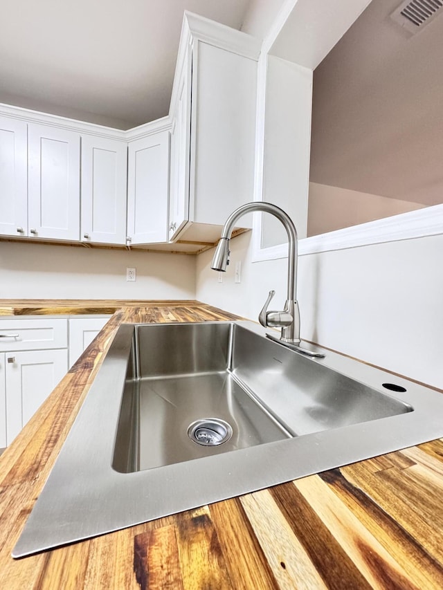 710 Gadsden Loop, Walterboro, SC 29488 - kitchen view of butcher block counters, a sink, and white cabinets
