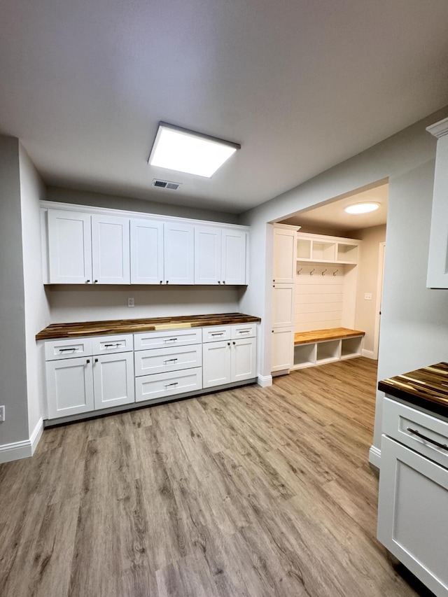710 Gadsden Loop, Walterboro, SC 29488 - kitchen with butcher block counters, light wood-type flooring, baseboards, and white cabinetry