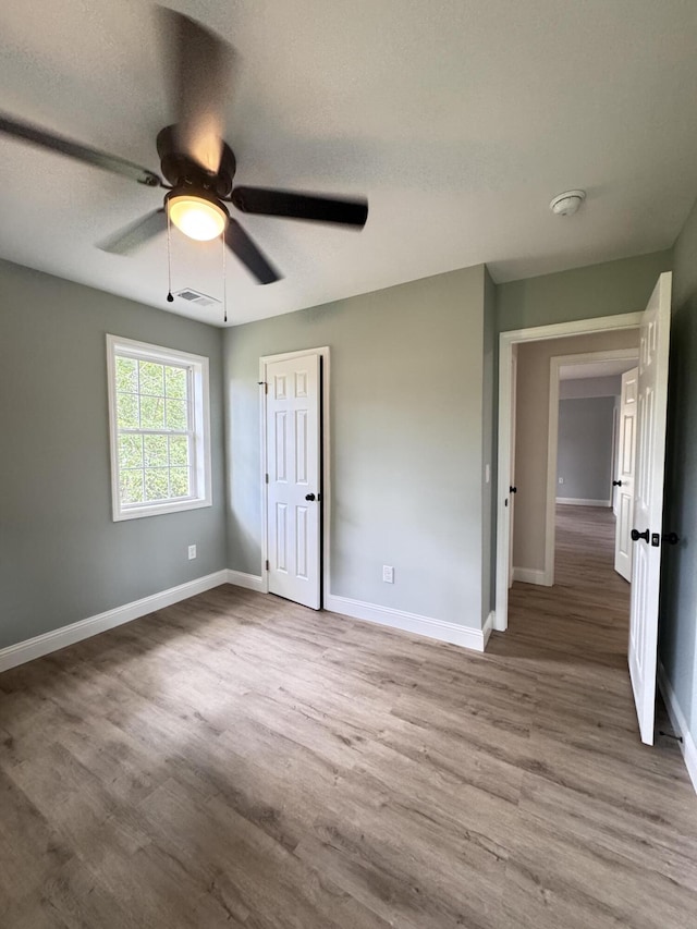 710 Gadsden Loop, Walterboro, SC 29488 - unfurnished bedroom with wood finished floors, baseboards, and a ceiling fan