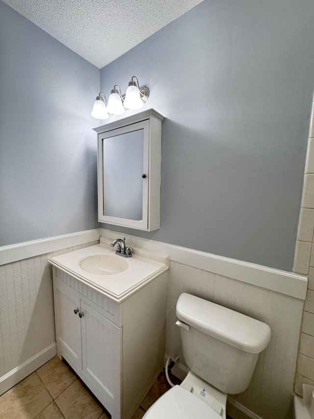 710 Gadsden Loop, Walterboro, SC 29488 - bathroom featuring vanity, toilet, a wainscoted wall, a textured ceiling, and tile patterned floors